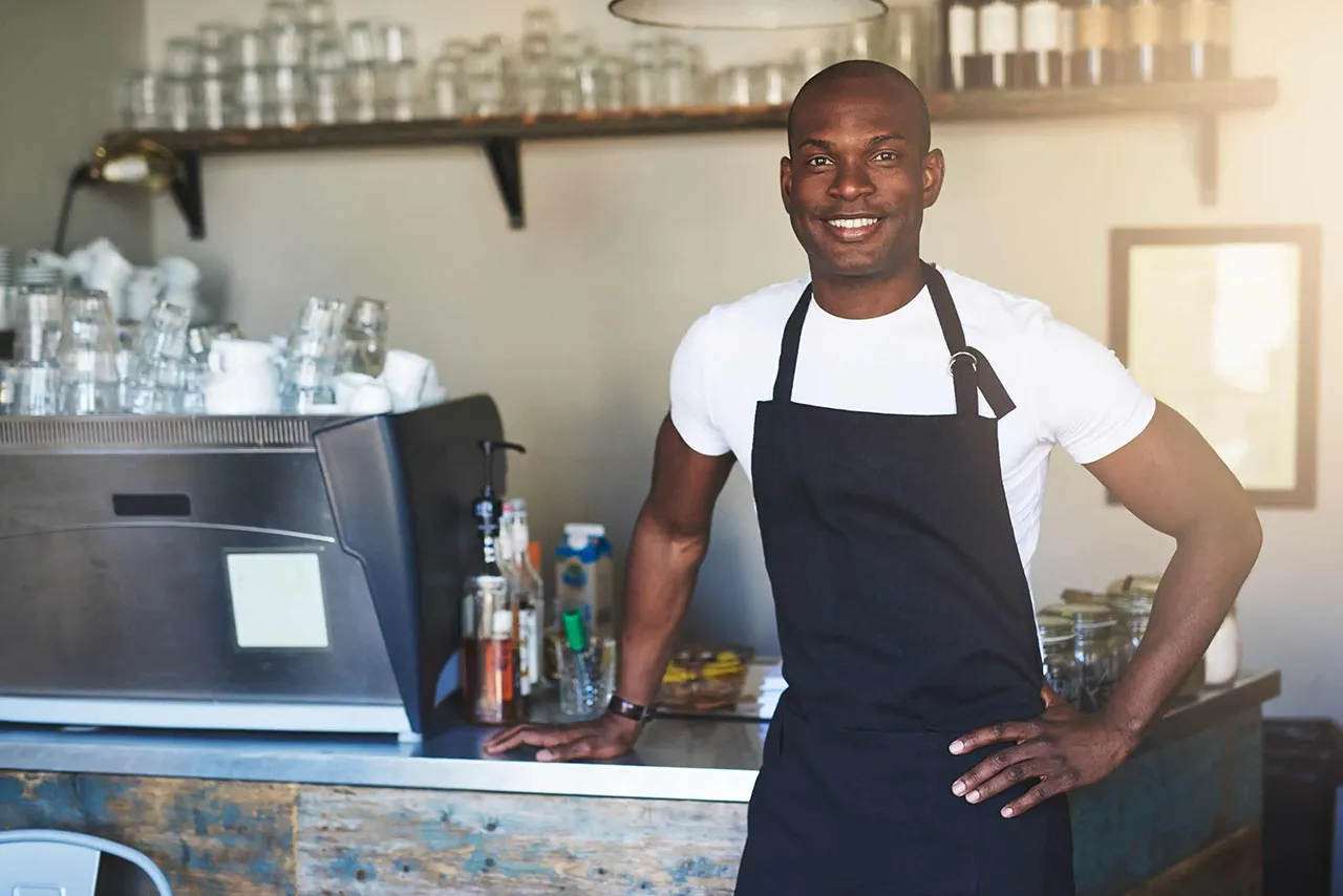 African American waiter standing in front of counter