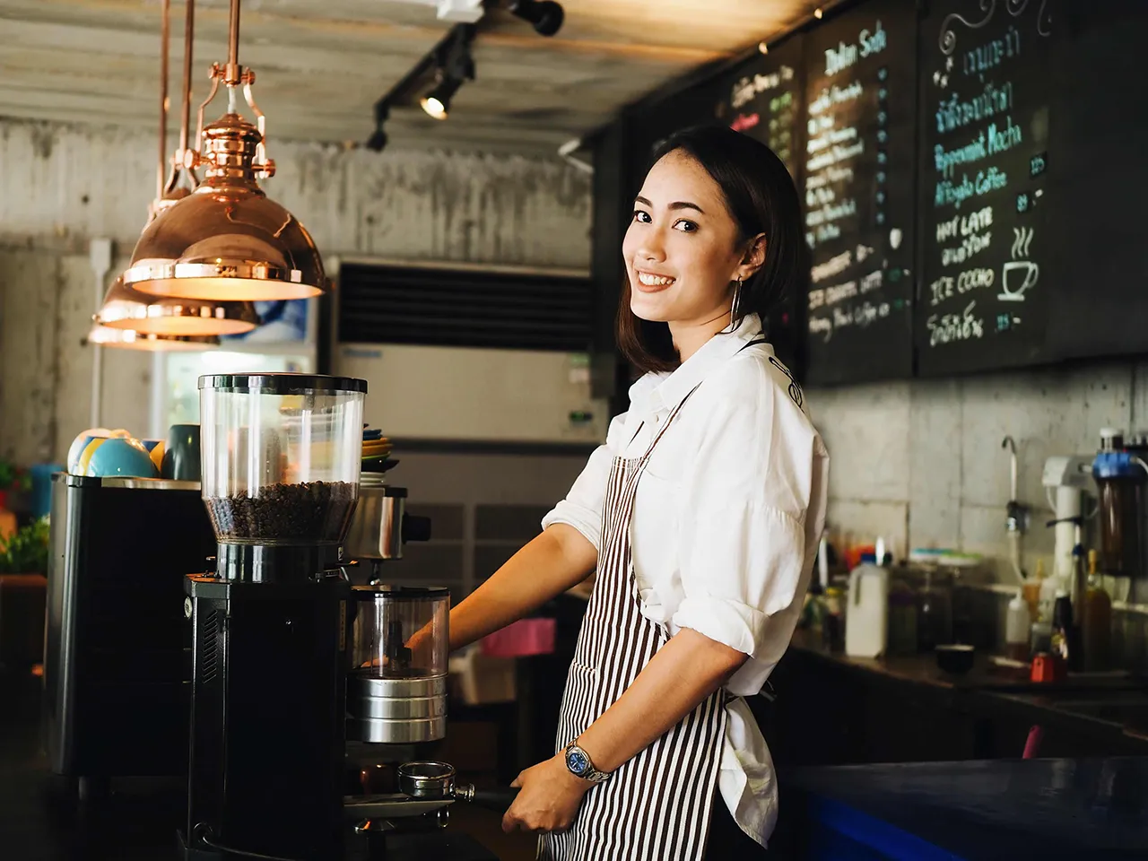 Female barista behind coffee machine
