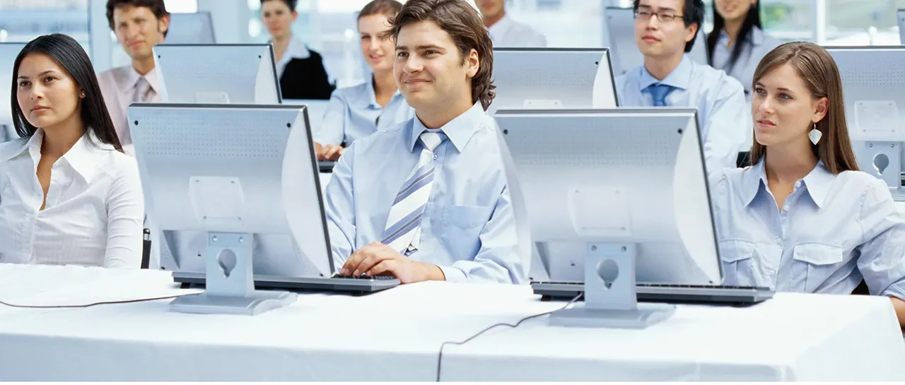 Group of employees behind computer screens