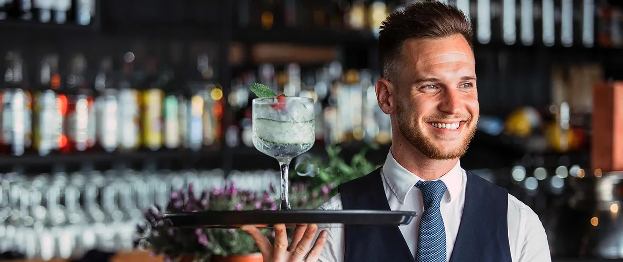Male server with a drink on a tray